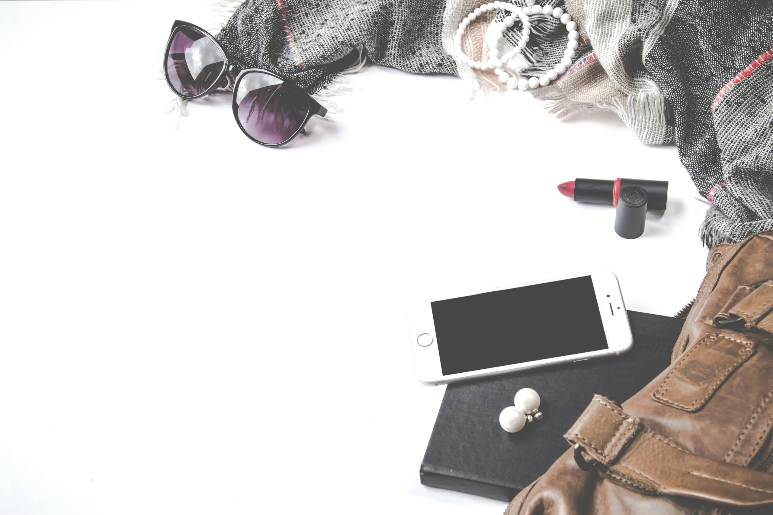 Stylish fashion flat lay with smartphone, sunglasses, and accessories.